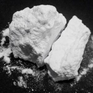 buying cocaine online in Canada, this photo shows two balls of Colombian Cocaine on a table with some powder by the sides ready to be snorted.